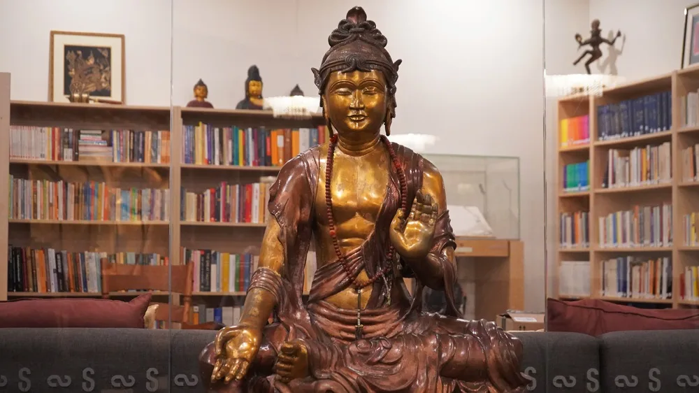 La bibliothèque du Centre, ses rayons de livres de croissance spirituelle et une statue en bronze